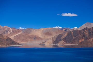 View of majestic rocky mountains against the blue sky and lake Pangong in Indian Himalayas, Ladakh region, India. Nature and travel concept