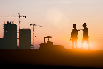 Wall Mural - Silhouette of engineer and construction team working at site over blurred background for industry background with Light fair.Create from multiple reference images together