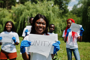 group of happy african volunteers hold blank board with unity sign in park. africa volunteering, cha
