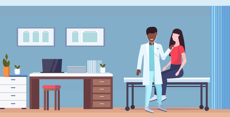 Wall Mural - african american doctor examining woman patient by stethoscope checking heart beat or breath medicine healthcare concept modern hospital office interior full length horizontal