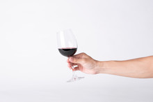 Man Hand Holding A Wine Glass On A Gray Background.