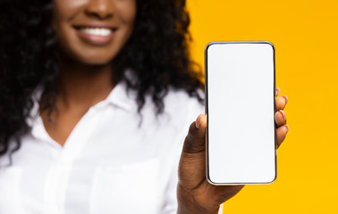 African millennial woman showing blank cellphone screen