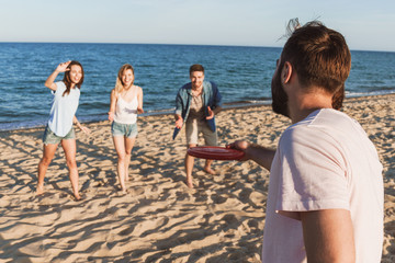 Poster - Happy young friends playing with frisbee at the beach