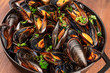 A full braiser of marinara mussels on a dark rustic background, close-up photo
