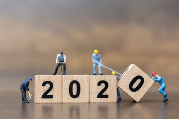 Miniature people : Worker team create wooden block number 2020  , Happy new year concept