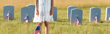 Panoramic Shot Of Kid In White Dress Standing On Graveyard With American Flag