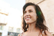 © Drobot Dean - Portrait of cute brunette woman smiling and looking aside on city street