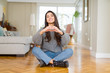 © Krakenimages.com - Young beautiful woman sitting on the floor at home smiling in love showing heart symbol and shape with hands. Romantic concept.