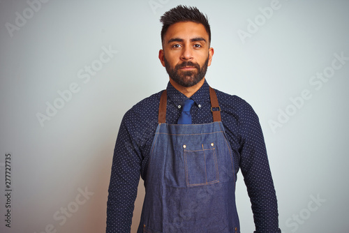 Young Indian Employee Man Wearing Apron Uniform Standing Over