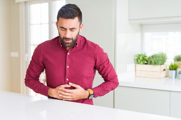 Canvas Print - Handsome hispanic business man with hand on stomach because indigestion, painful illness feeling unwell. Ache concept.