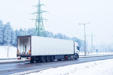 Cargo truck on winter road, snow and frost landscape