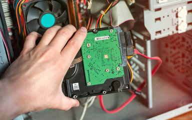 A technician repairing a computer with different tools. Computer support engineer changing the hard drive of an office Computer.