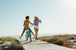 © Jacob Lund - Two women having fun with a bicycle at beach