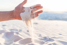 White Sands Dunes National Monument Man Hand Holding Sand Falling Grains In New Mexico At Sunset