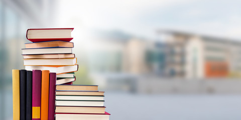 stacked books with school in the background, concept back to school