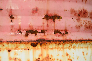 Red painted metal background with rust. Close-up