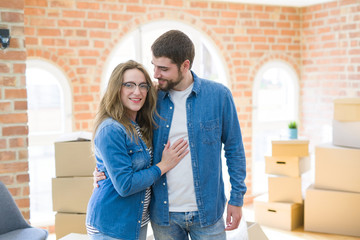 Young couple around cardboard boxes very happy moving to a new home