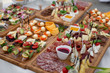 Large selection of food with cold snacks, salads, cold meats, cheese and jam served. Variety of tasty delicious snacks on the table. Wedding reception