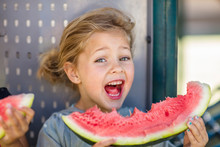 Portrait Of Happy Girl Eating A Watermelon In Kindergarten