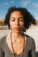 Close-up Portrait Of African American Attractive Young Woman Meditating At The Beach