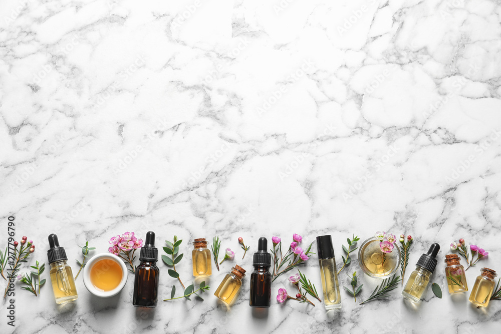 Flat lay composition with bottles of natural tea tree oil and space for text on white marble background - obrazy, fototapety, plakaty 