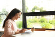 © New Africa - Young woman reading book at table in library. Space for text