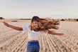 © Eva - Summer Girl enjoying nature on yellow field. Beautiful young woman dancing Outdoors. Long hair in the wind. Happiness and lifestyle. Back view