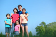 © Kenishirotie - Happy Asian family with children outdoors in park during summer