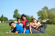 © Kenishirotie - Happy Asian family with children outdoors in park during summer