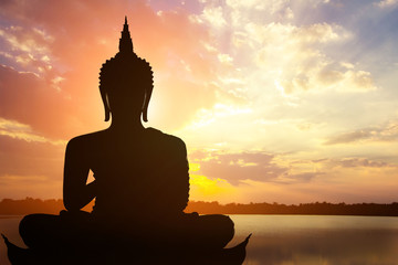 Magha Asanha Visakha Puja Day , Silhouette Buddha on golden sunset background.