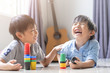 funny two boys playing with colourful cup toys on floor.Asian little boys playing stack cup at home