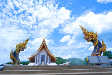 Two Naga statue,King of nagas Serpent animal in Buddhist legend on blue sky clouds in background and Sign Prayer in thai language at wat dhammayan,Thailand