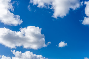 fluffy white clouds against a bright, colorful blue sky