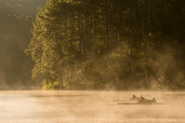 Wall Mural - people get on bamboo raft, morning adventure in winter with fog float on surface water
