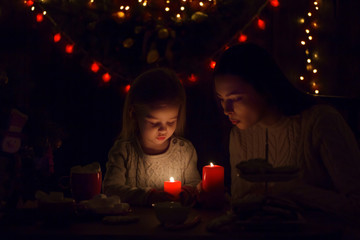 Wall Mural - Mother and little girl with burning candle   at home