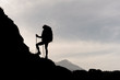 Silhouette of female hiker climbing on mountain