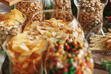 Wall Mural - Delicious beer appetizers table at wedding reception. Chips, salty nuts, pistachio, cheese snacks on table at wedding or christmas feast. Luxury catering concept. Beer bar