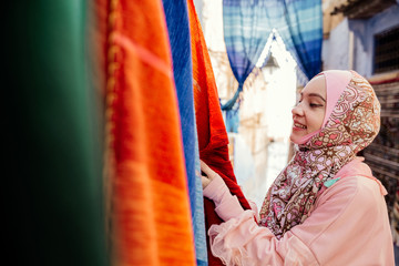 Tourist on a street with carpets - Chefchaouen, Morocco