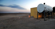 A Hut And A Water Tank In The Middle Of The Desert In Saudi Arabia At Sunset