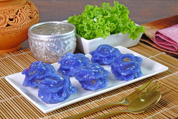 Royal Thai cuisine : Purple blue color Flower-shaped Thai dumpling (Khanom Chor Muang) Famous ancient Thai appetizers.