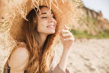 Wall Mural - Pleased gorgeous attractive woman posing outdoors at the sea beach.