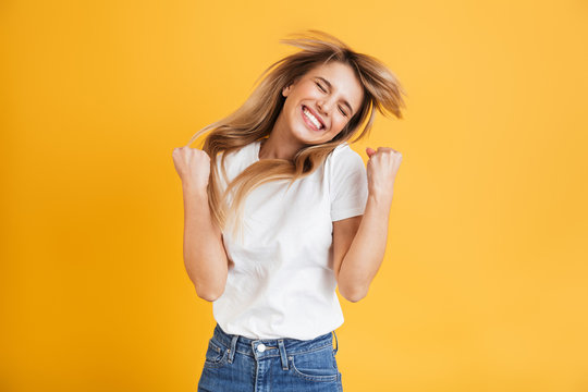 emotional young blonde woman posing isolated over yellow wall background dressed in white casual t-s