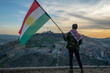 Teenager holding the Kurdistan flag in northern Iraq at sunset time on Nowruz 2019