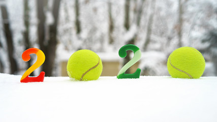 Wall Mural - Tennis Christmas and 2020 New Year concept with tennis balls and candles with numbers on white snow, isolated. Top view, copy space. Winter sport healthy layout. Holiday conception. Banner size.