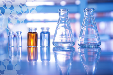 Wall Mural - glass flask and blue and orange solution in vial for medical science and education experiment labora
