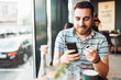 © aboutmomentsimages - handsome man making a payment on smartphone using credit card. Mobile shopping concept