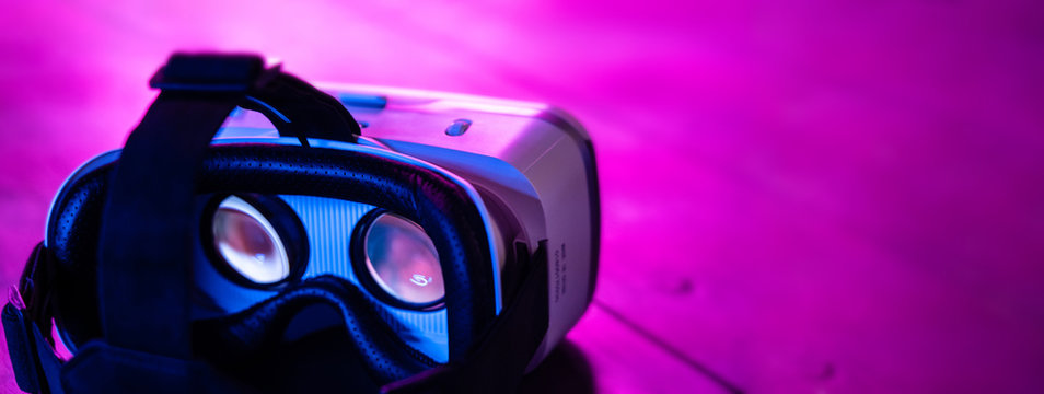 vr 3d 360 headset glasses goggles in futuristic purple neon light on table desk, virtual augmented a