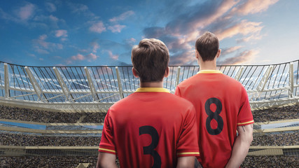 Wall Mural - two soccer player standing against the crowded stadium on background