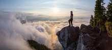 Adventurous Female Hiker On Top Of A Mountain Covered In Clouds During A Vibrant Summer Sunset. Taken On Top Of St Mark's Summit, West Vancouver, British Columbia, Canada.
