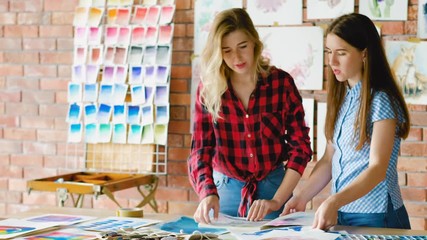 Wall Mural - Art school master class prep. Women setting up creative workspace with color palettes, drawings and tools